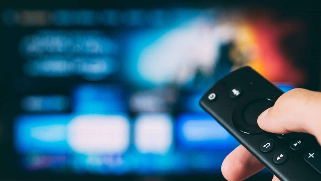 Mando de televisión y pantalla difuminada al fondo